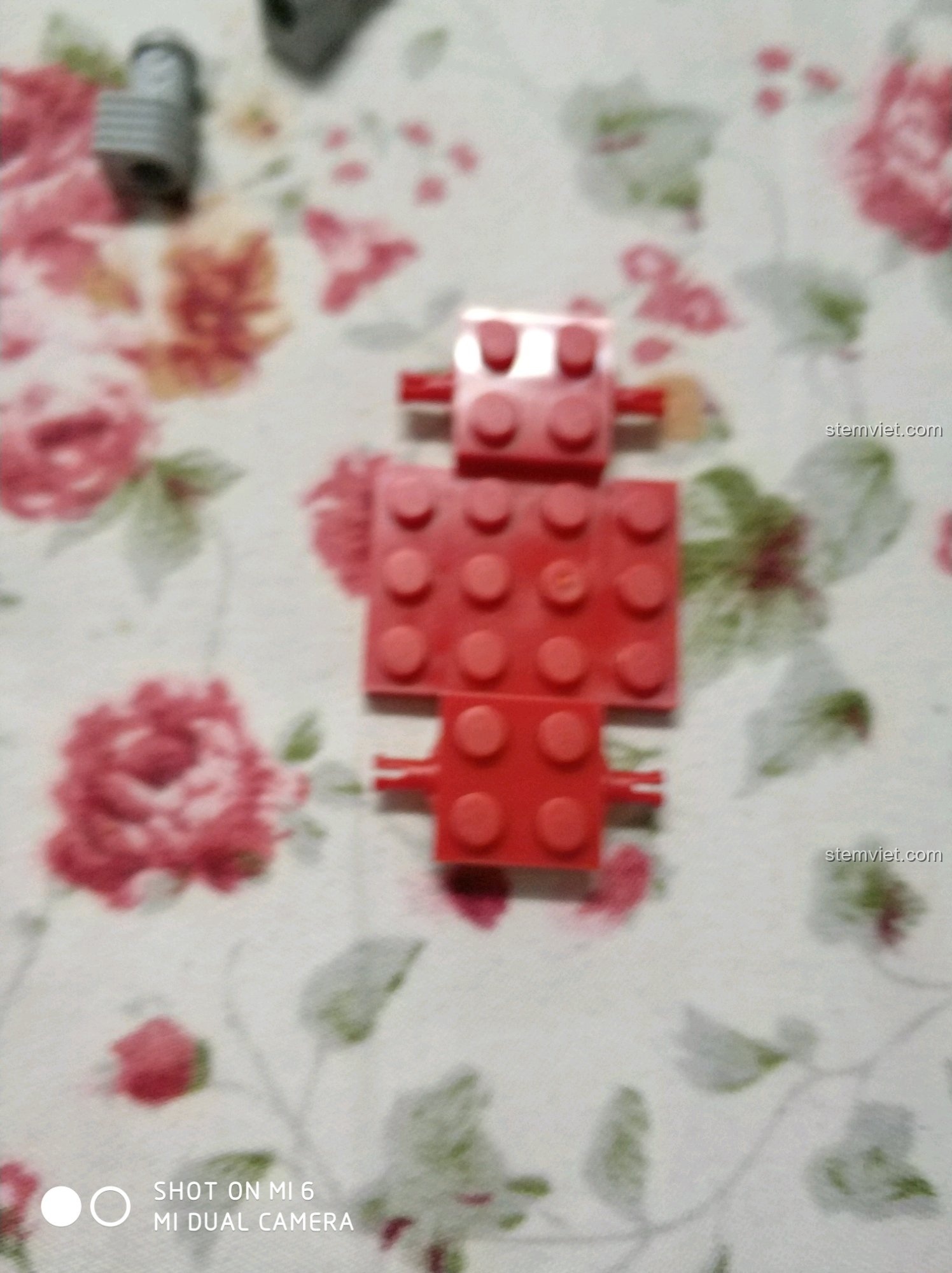 Xe đua mini được đặt gọn gàng bên trong container của bộ Enlighten 0493 Xe Nâng Hàng Chuyên Dụng, thể hiện tính năng chơi.