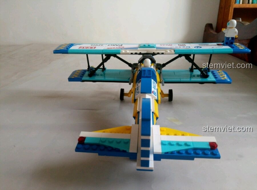 Góc nhìn từ phía sau mô hình máy bay biểu diễn hai cánh Enlighten 1125, cho thấy phần đuôi và bánh xe sau.