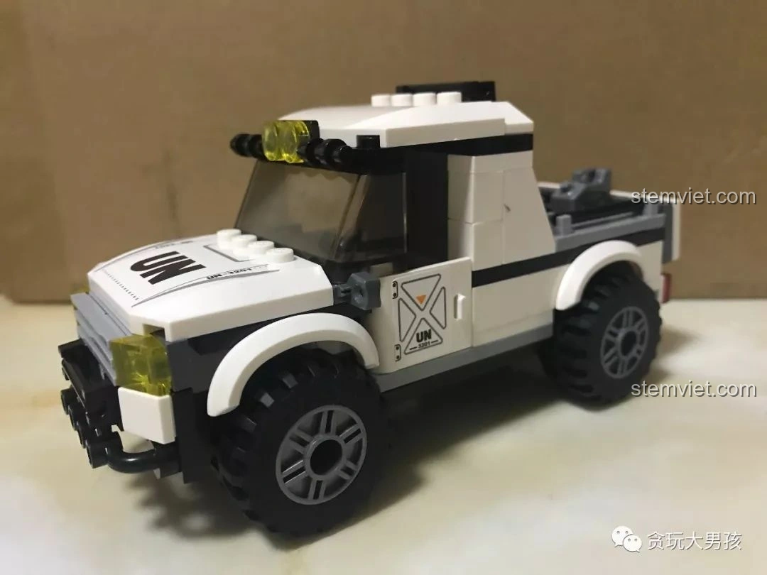 Góc nhìn 3/4 của mô hình xe bán tải quân sự Enlighten 3201 ThunderMission đã lắp xong, thể hiện chi tiết bánh xe và đèn pha. Review Enlighten 3201.