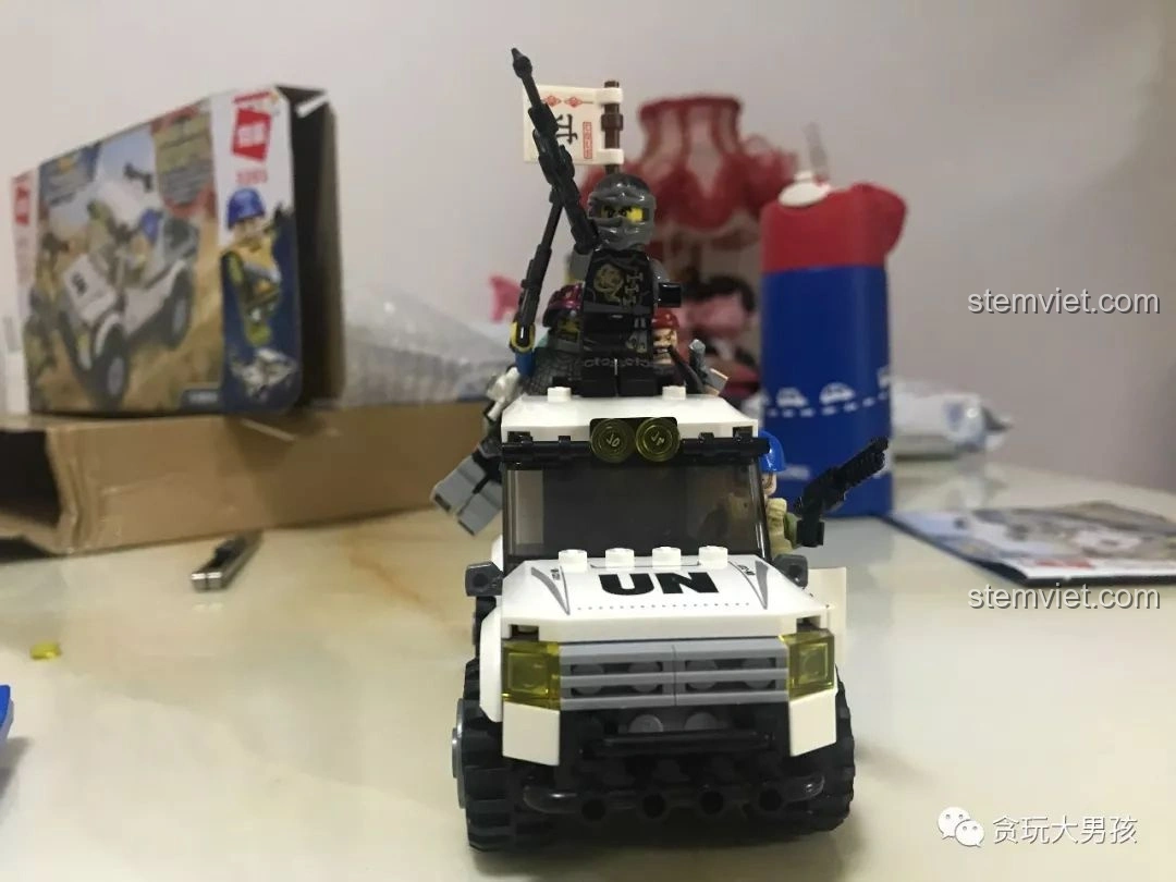 Bé trai đang chơi với mô hình xe bán tải quân sự Enlighten 3201 ThunderMission, thể hiện niềm vui và sự tương tác. Đánh giá Enlighten 3201.