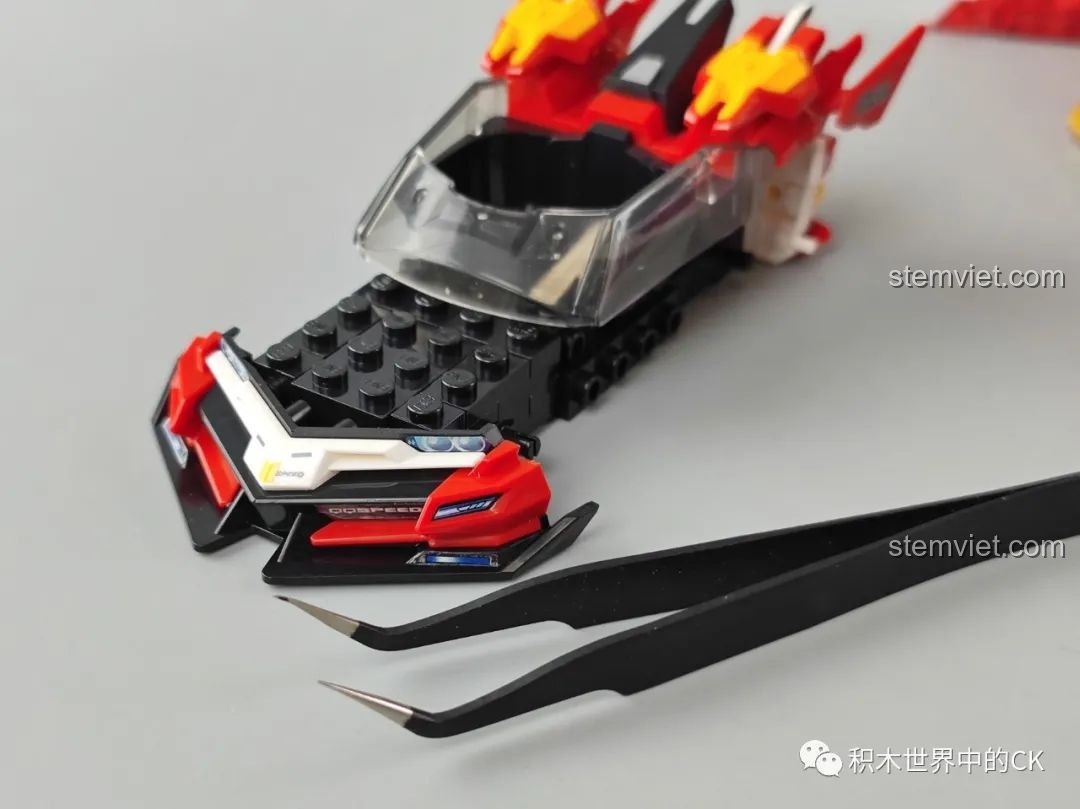 Quá trình gắn các chi tiết nhỏ lên mô hình xe đua Tôn Ngộ Không Enlighten 74021 bằng nhíp, thể hiện sự tỉ mỉ trong lắp ráp.