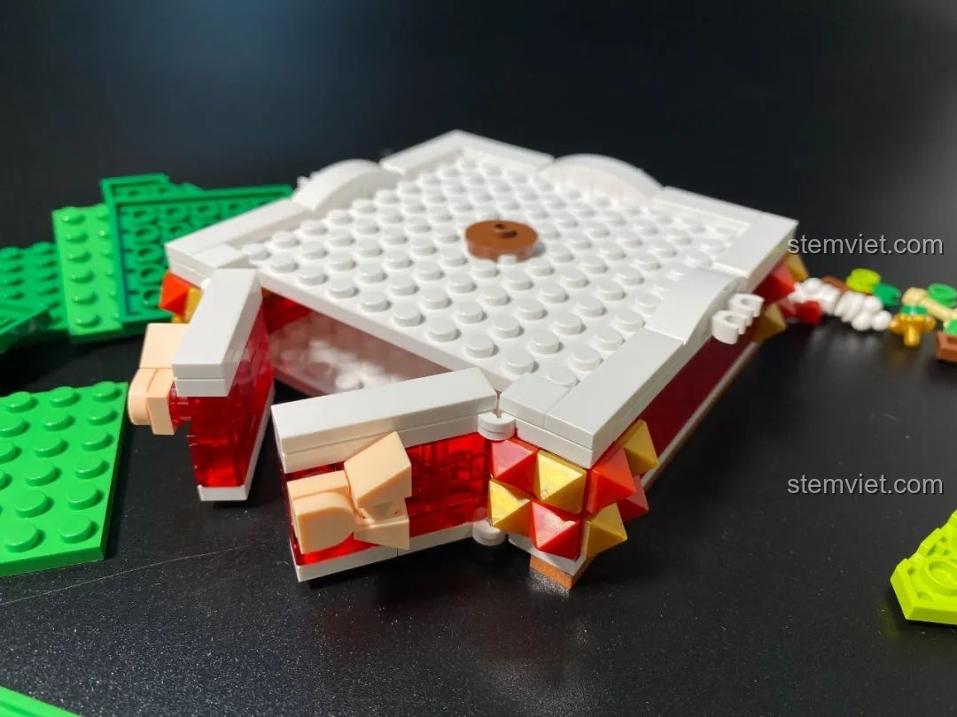 Phần đế của đồ chơi lắp ráp JAKI JK5111 Cây Thông Giáng Sinh đang được lắp, có khe hở để đựng đồ.