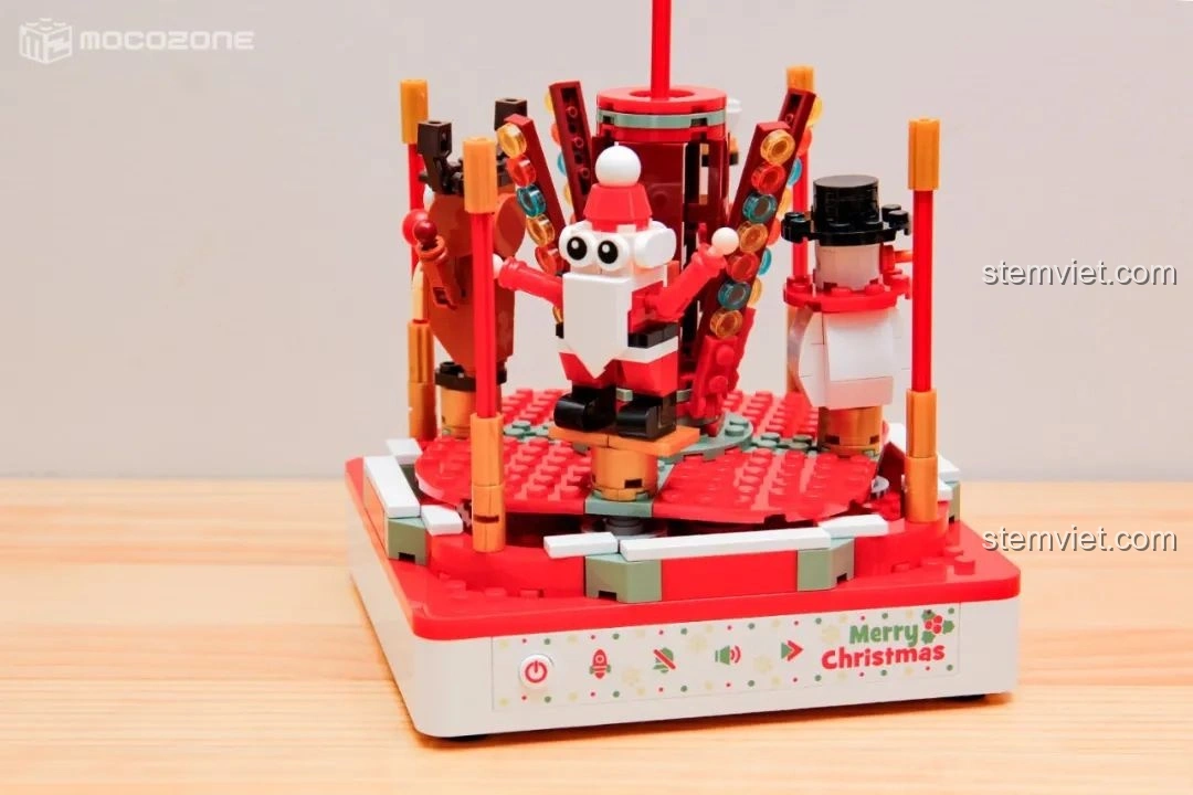 Ba trong bốn minifigure (Ông già Noel, Người tuyết, Lính chì Nutcracker) đã được đặt lên phần đế của Hộp nhạc Giáng Sinh Xoay Tự Động JAKI JK1365, sẵn sàng cho vòng quay.