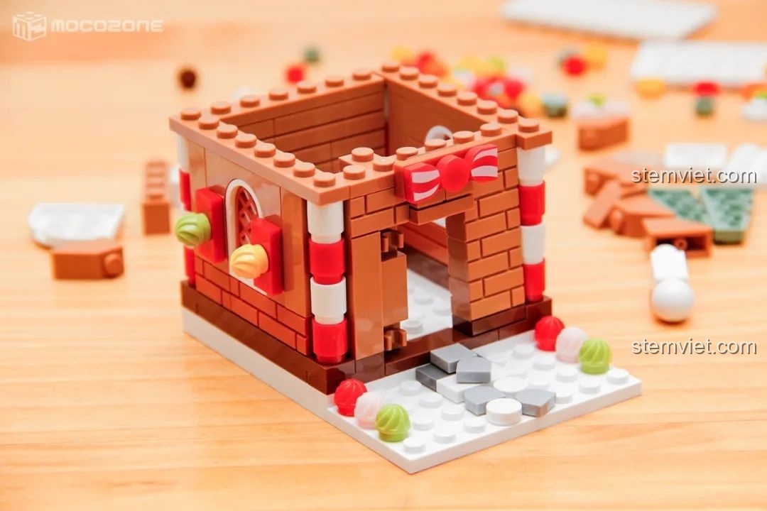 Ngôi nhà bánh gừng đang dần hoàn thiện, với các chi tiết trang trí kẹo và cột kẹo.
