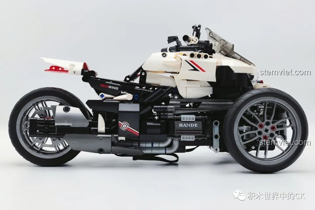 Mô hình JIESTAR 91024 Mô Tô Ba Bánh Honda Neo Wing RC hoàn chỉnh nhìn từ góc thấp bên hông, chi tiết ống xả và động cơ được tái hiện. Đây là đồ chơi lắp ráp xe mô tô điều khiển từ xa.
