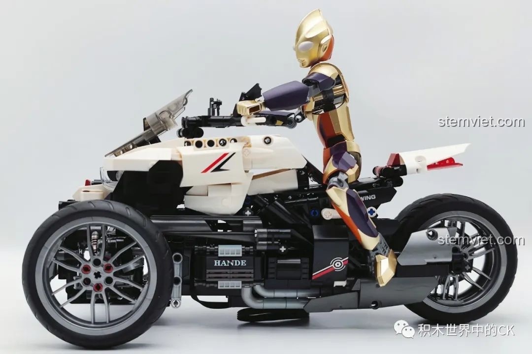 Mô hình JIESTAR 91024 Mô Tô Ba Bánh Honda Neo Wing RC được trưng bày cùng hai figure đang tương tác, tạo nên cảnh