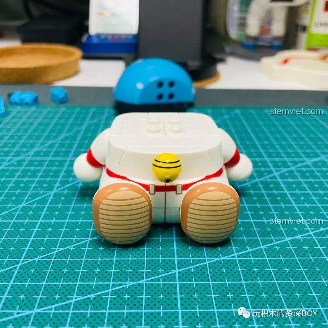 Phần đế đầu màu đỏ được lắp vào thân của mô hình Doraemon phi hành gia K20413, chuẩn bị cho việc gắn đầu.