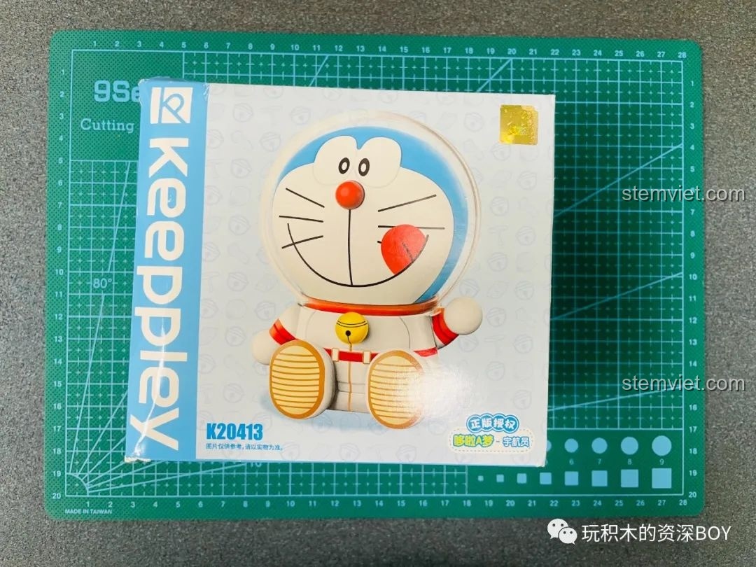 Hộp đồ chơi lắp ráp Keeppley Doraemon phi hành gia K20413 đặt trên thảm cắt, cho thấy thiết kế bao bì đáng yêu và thông tin sản phẩm.