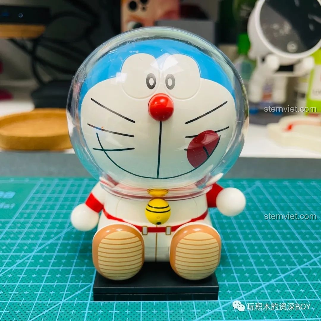 Mô hình Doraemon phi hành gia K20413 đã hoàn thiện đặt cạnh hộp sản phẩm, cho thấy sự giống nhau đáng kinh ngạc.