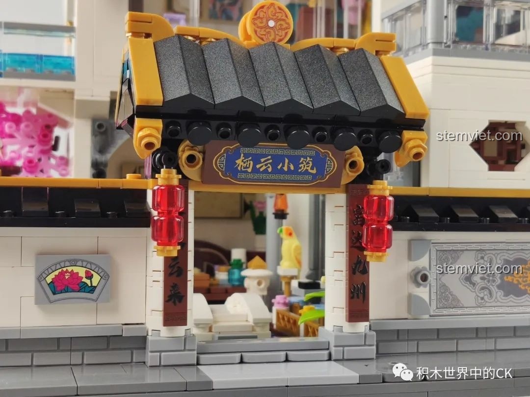 Cận cảnh cửa sổ và ban công tầng trệt của mô hình Phố Cổ Phong Cách Trung Hoa Mới: Tê Vân Tiểu Trúc K18002, với cây hoa anh đào và chú mèo.