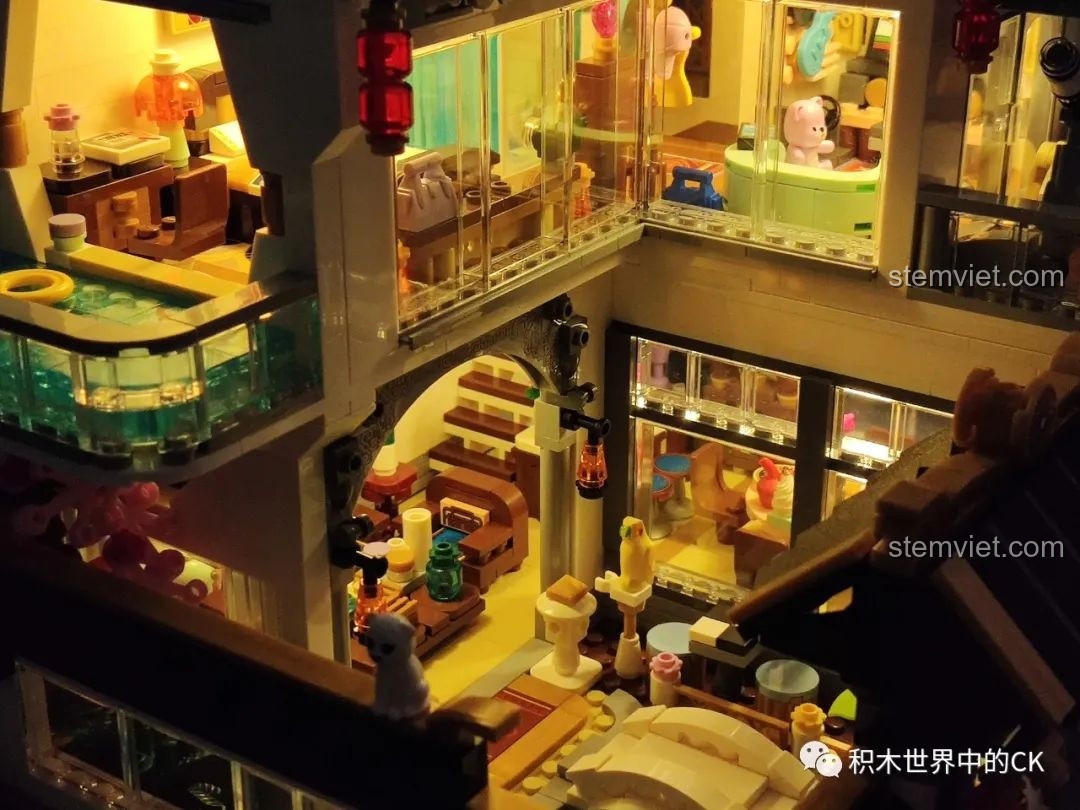 Phòng khách và bếp của mô hình Keeppley K18002 Tê Vân Tiểu Trúc sáng bừng trong đêm, tạo không gian ấm cúng.