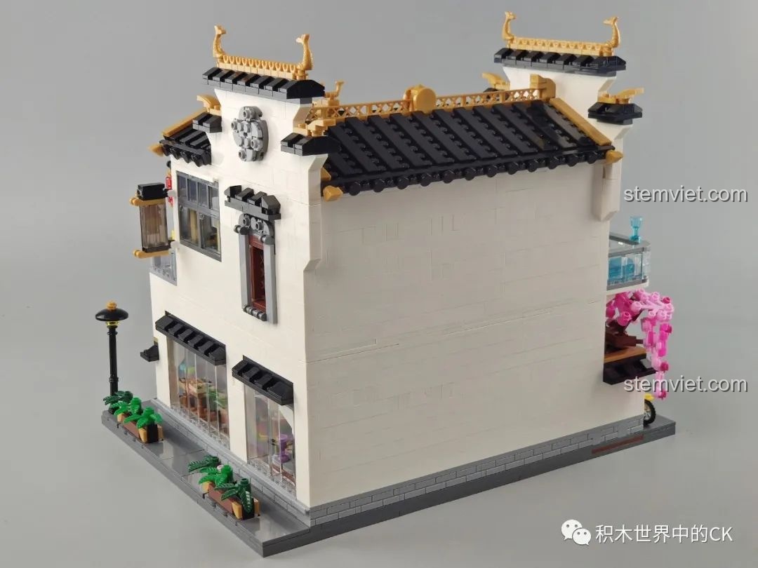 Góc nhìn từ phía sau bên hông của mô hình Phố Cổ Phong Cách Trung Hoa Mới: Tê Vân Tiểu Trúc K18002, nổi bật cây hoa anh đào hồng.