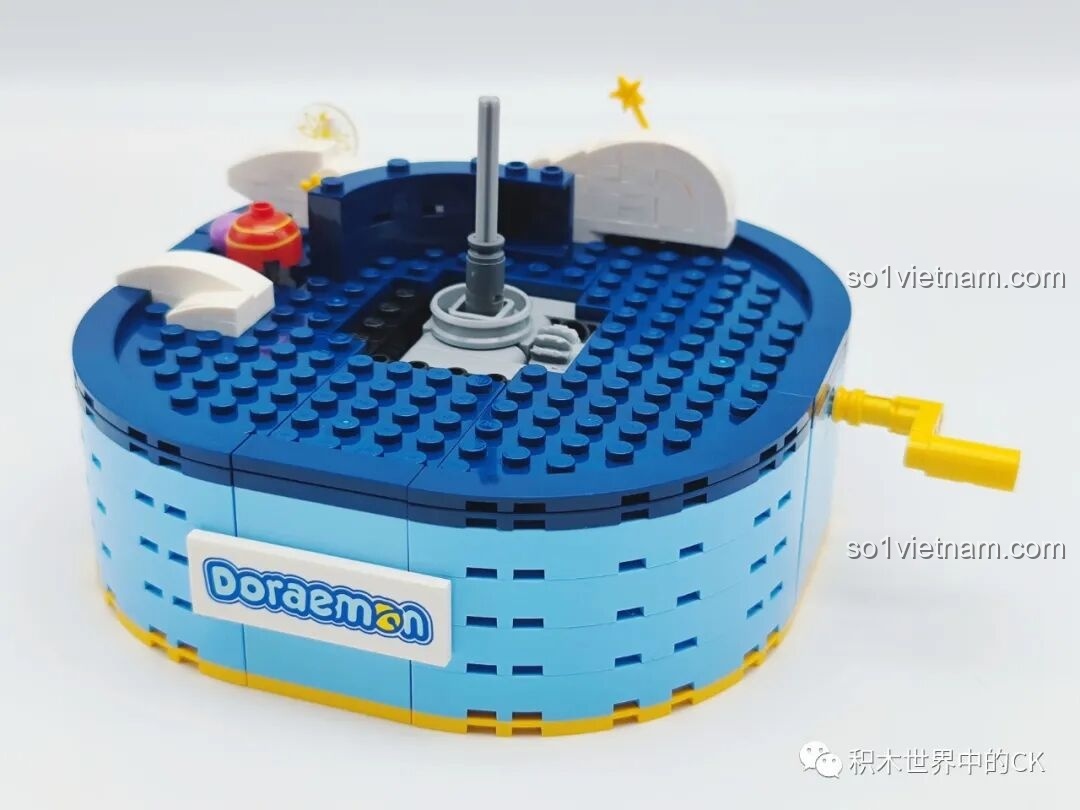 Phần đế của mô hình Keeppley K20421 Doraemon đã hoàn thành, với logo Doraemon nổi bật và tay quay cơ chế xoay.