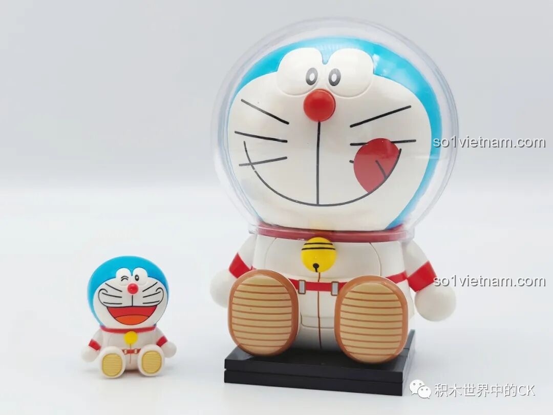 So sánh kích thước giữa minifigure Doraemon phi hành gia K20421 lớn và một minifigure Doraemon nhỏ hơn, thể hiện sự đa dạng về tỷ lệ.