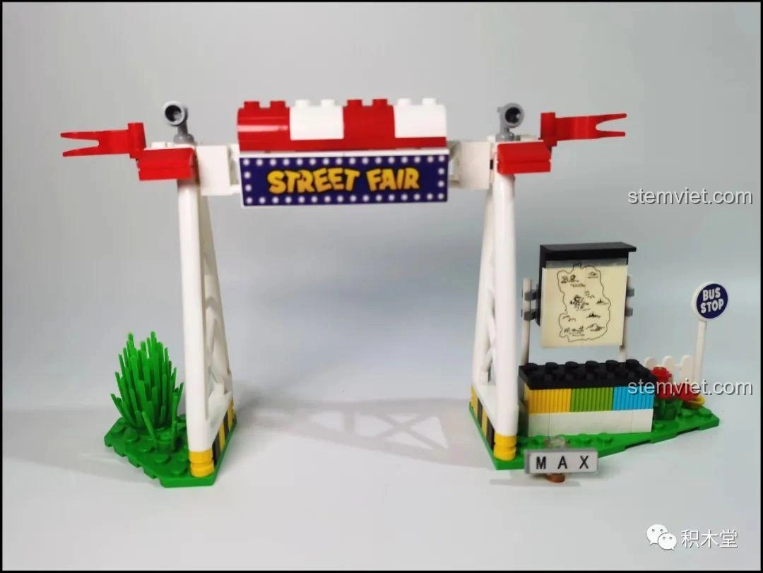 Cổng hội chợ Street Fair đã hoàn thiện trong bộ lắp ráp LiNooS LN8006 Snoopy Xe Buýt Trường Học, với biển hiệu màu xanh và đỏ.