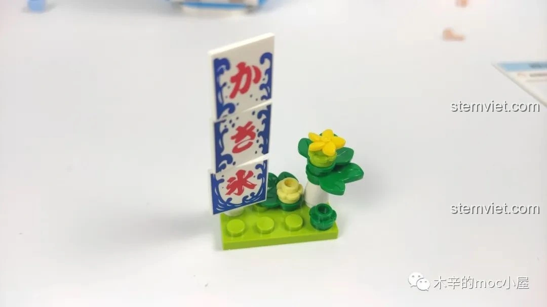 Cận cảnh biển hiệu và chi tiết hoa nhỏ bên ngoài tiệm kem đá bào Wekki 506041, có thể hơi lỏng lẻo.