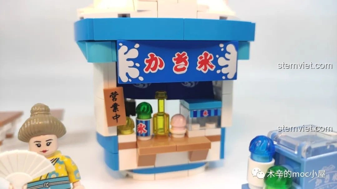 Cận cảnh quầy bán kem của bộ Tiệm kem đá bào Wekki 506041 với các chai siro và biển hiệu in ấn sắc nét.