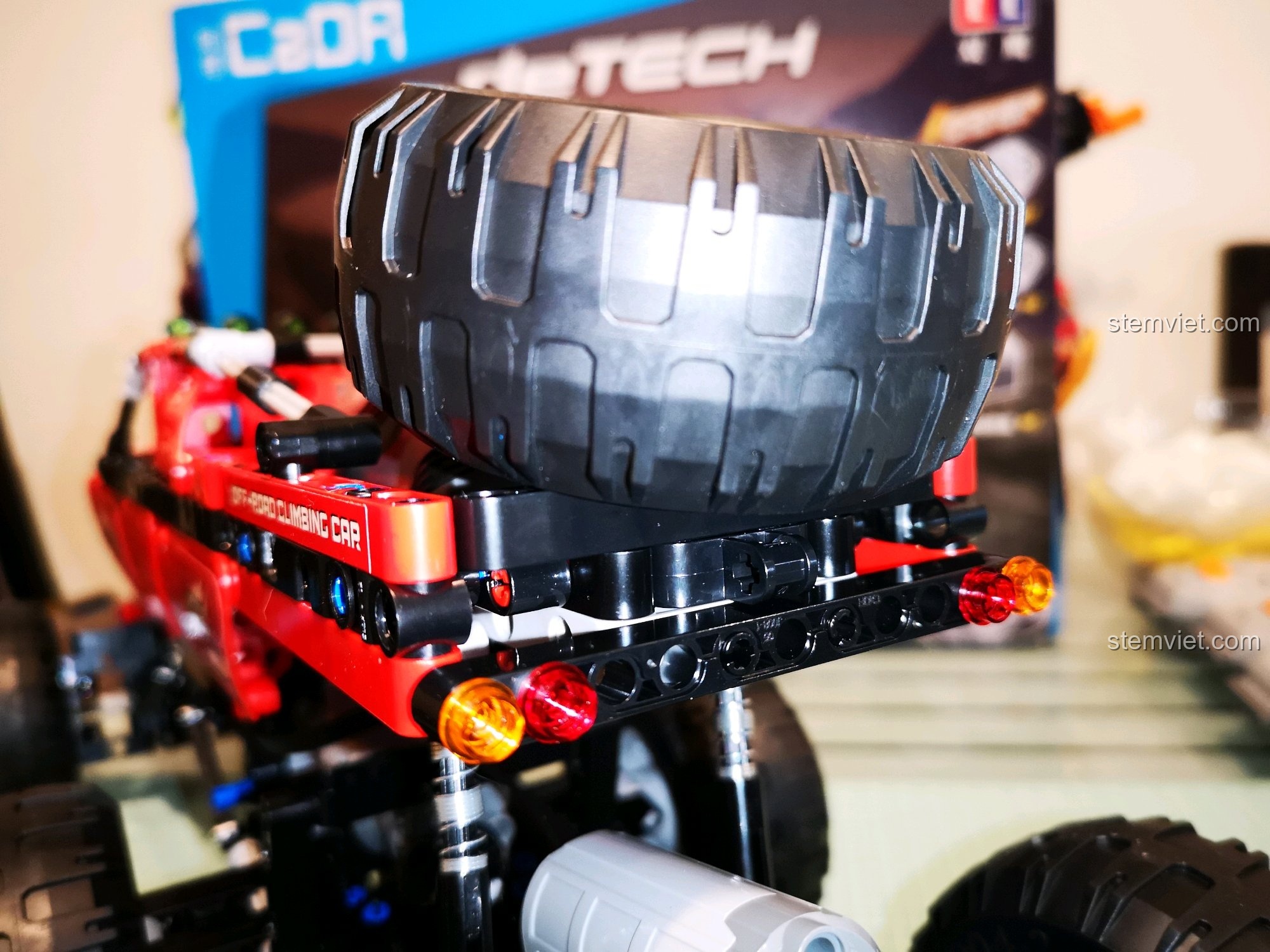 Cận cảnh đèn pha và các chi tiết phía trước của xe CaDA C51041 MOC 6x6, với các đèn phụ màu xanh lá nổi bật. Đánh giá CaDA 1041 Xe Địa Hình Điều Khiển Từ Xa.