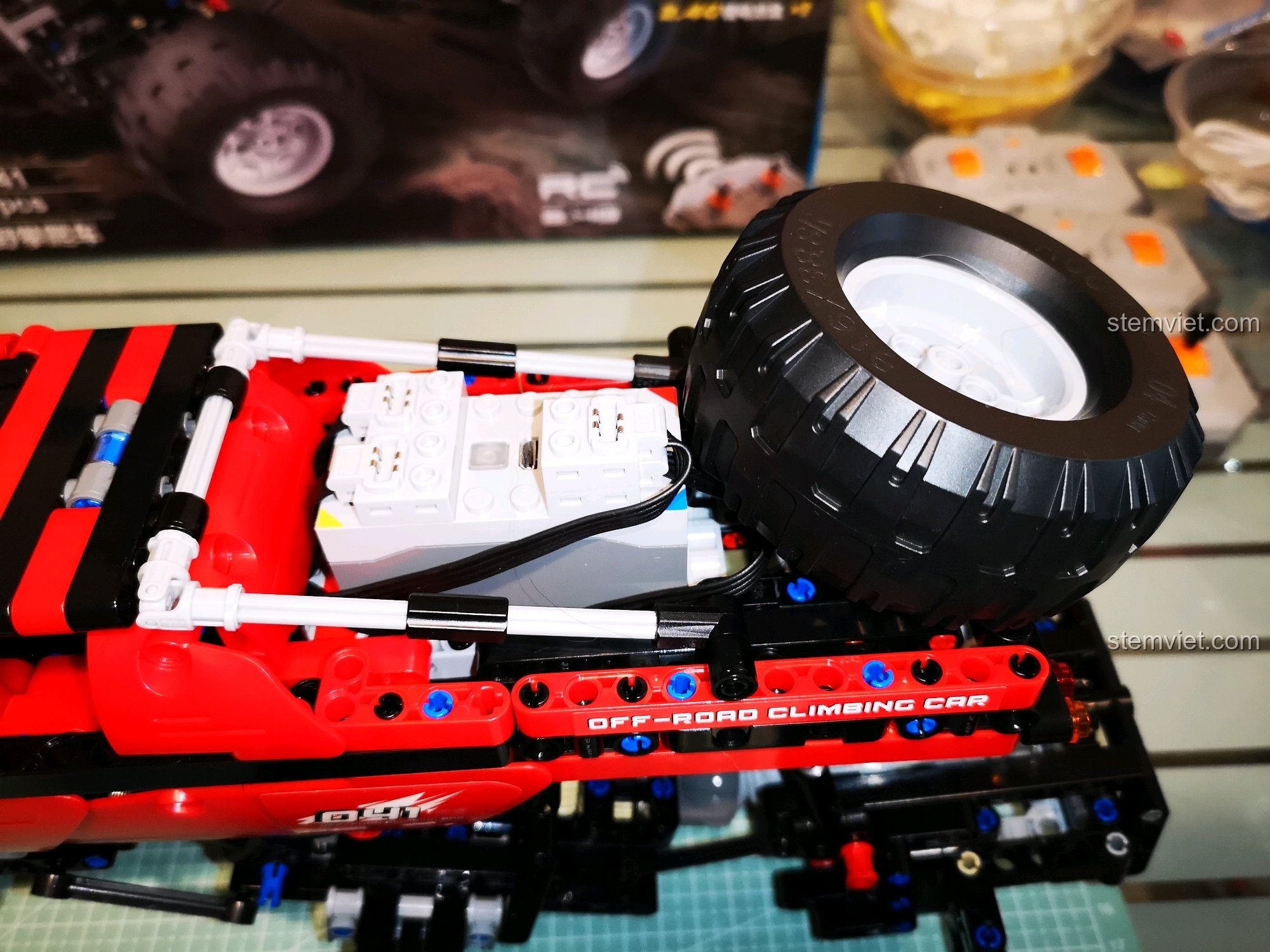 Cận cảnh trục trước của xe CaDA C51041 MOC 6x6, với hệ thống lái và giảm xóc, đảm bảo khả năng điều khiển chính xác. Đánh giá CaDA 51041 Xe Off-Road RC.