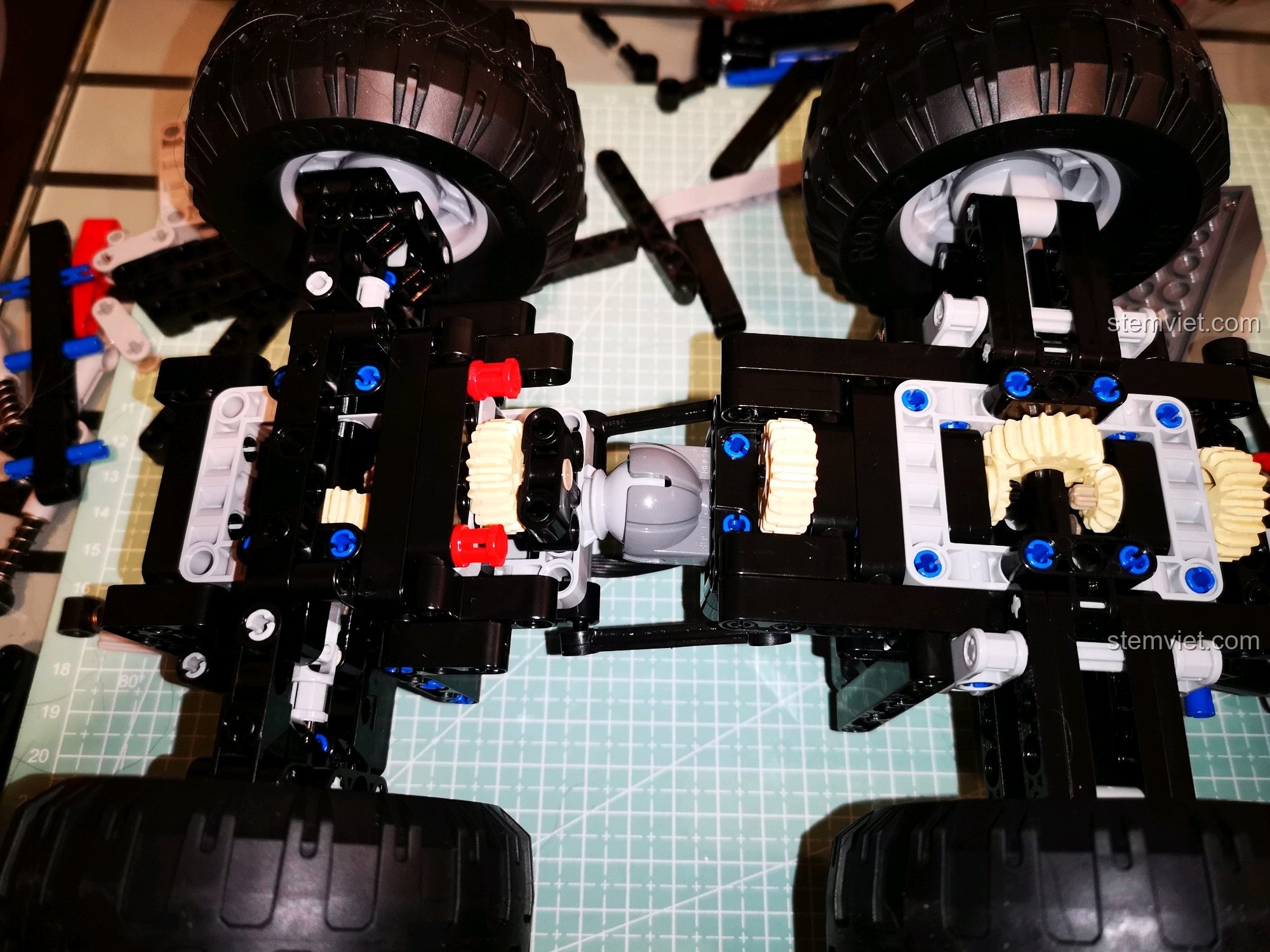 Góc nhìn rộng hơn về các khớp nối trục và hệ thống treo của xe CaDA C51041 MOC 6x6, thể hiện sự linh hoạt và khả năng thích ứng địa hình. Cảm nhận CaDA 1041 Xe Leo Núi Địa Hình.