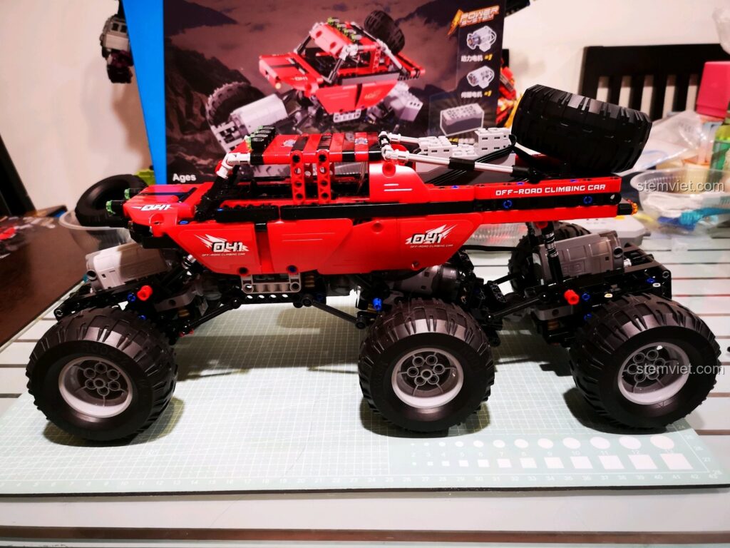 Xe địa hình CaDA C51041 MOC 6x6 màu đỏ cực ngầu, đứng cạnh hộp sản phẩm, sẵn sàng chinh phục mọi thử thách. Đánh giá CaDA C51041 Xe Off-Road RC.