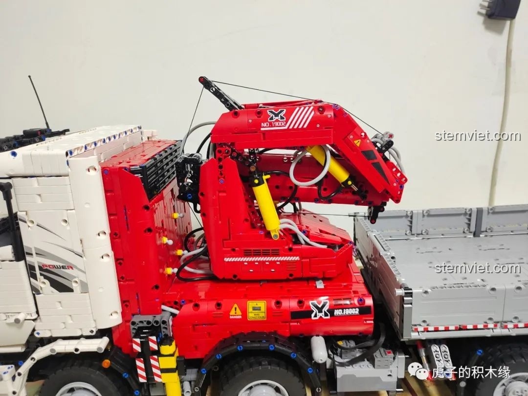 Cần cẩu của xe tải Mould King 19002 đang trong trạng thái nâng cao, thể hiện sức mạnh của hệ thống khí nén. Review Mould King 19002.