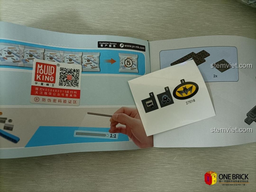 Sách hướng dẫn lắp ráp và bộ decal dán cho mô hình Batmobile Mould King 27018, giúp hoàn thiện các chi tiết nhỏ.