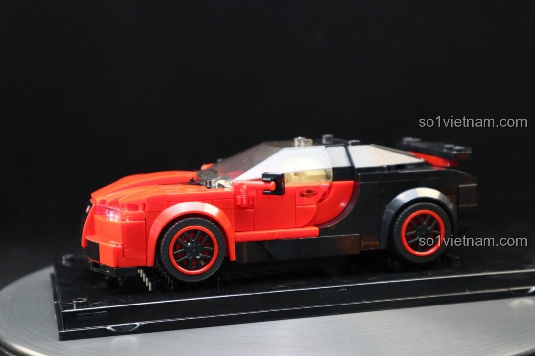 Mô hình Bugatti Veyron Mould King 27027 nhìn từ bên hông, thân xe đỏ đen, đặt trên đế xoay.