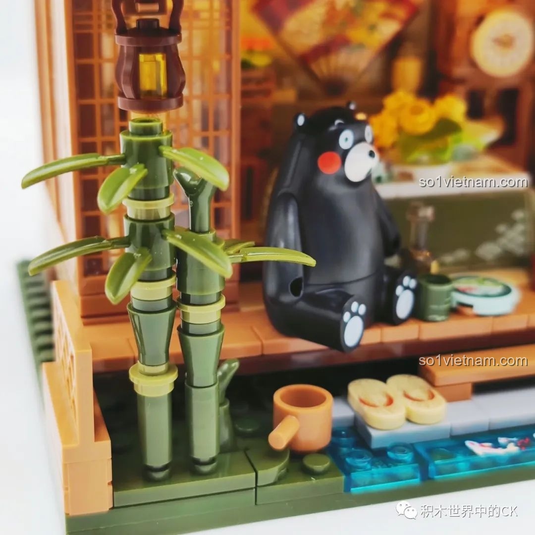 Cận cảnh Kumamon ngồi bên bàn trà với các món ăn và đồ uống nhỏ trong Ngôi nhà Nhật Bản Kumamon inbrixx 880018.