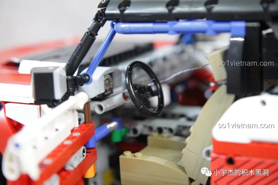 Cận cảnh bánh xe sau của PanlosBrick 673101 Ford Bronco, với lốp gai và vành đỏ.