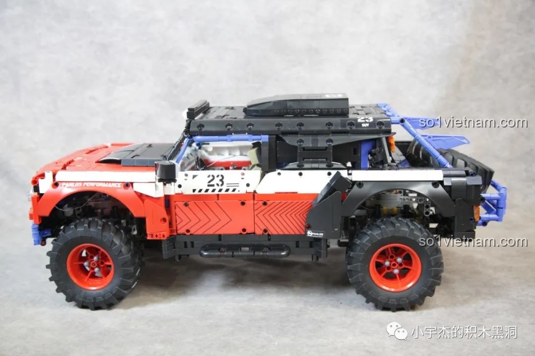 Cận cảnh bánh xe trước của PanlosBrick 673101 Ford Bronco, với lốp gai và vành đỏ nổi bật.