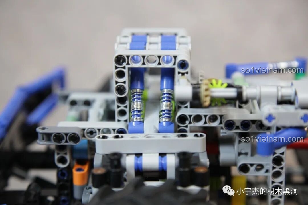 Cận cảnh hệ thống giảm xóc kép phía trước của PanlosBrick 673101 Ford Bronco Xe Địa Hình, với lò xo xanh nổi bật.