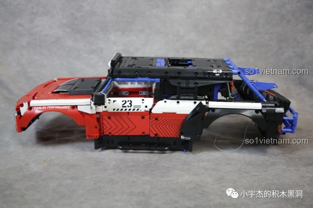 Vỏ xe của PanlosBrick 673101 Ford Bronco chưa lắp hoàn chỉnh, với các chi tiết màu đỏ, trắng, đen và khung chống lật xanh.