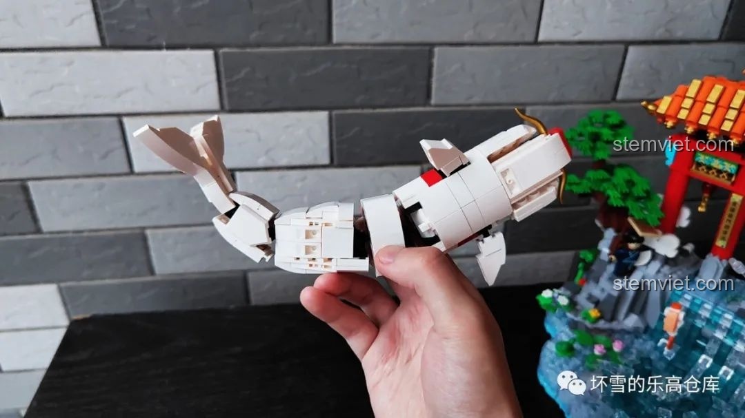 Mô hình cá chép của bộ lắp ráp Pantasy 18001 Cá chép hóa rồng được cầm trên tay, thể hiện khả năng chuyển đổi giữa hai chế độ.