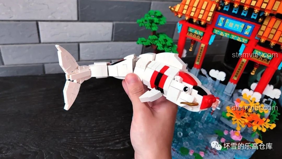 Mô hình cá chép của bộ lắp ráp Pantasy 18001 Cá chép hóa rồng được cầm trên tay, thể hiện khả năng uốn cong linh hoạt.