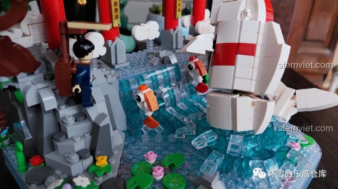 Hai chú cá nhỏ bơi lội gần thác nước trong bộ lắp ráp Pantasy 18001 Cá chép hóa rồng, tạo cảnh quan sống động.