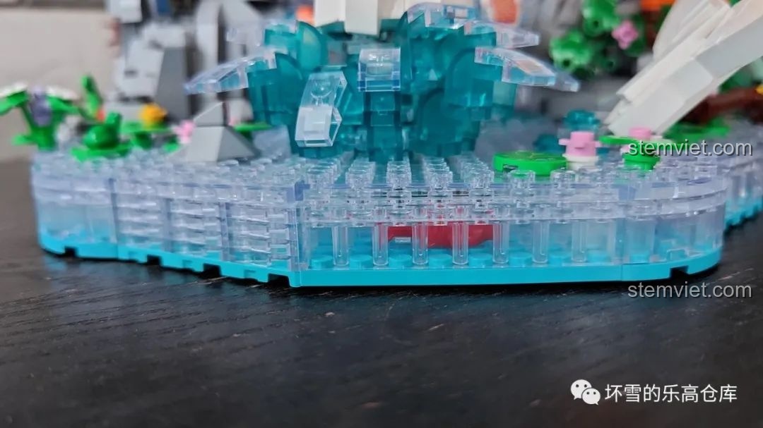 Góc nhìn cận cảnh phần đế nước trong suốt của bộ lắp ráp Pantasy 18001 Cá chép hóa rồng, thể hiện độ trong và chi tiết.