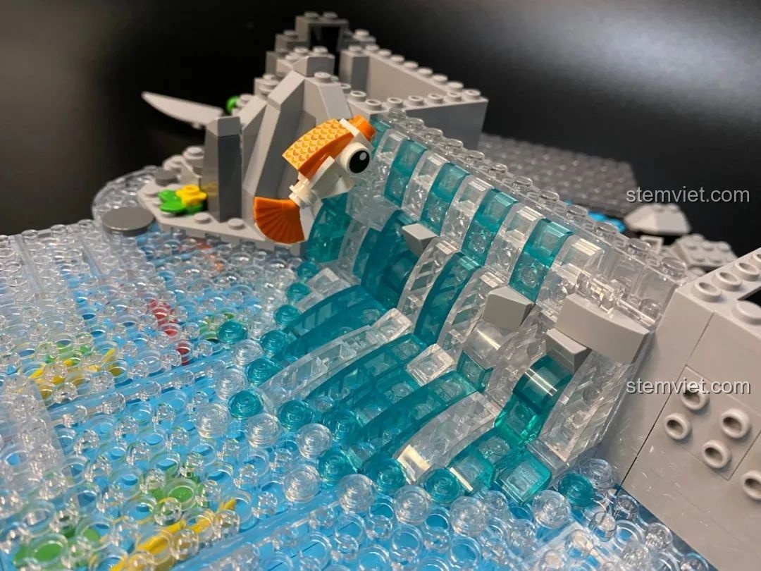 Hai chú cá chép nhỏ màu cam và đỏ đang được đặt vào vị trí bơi ngược dòng thác trong bộ Pantasy 18001 Cá Chép Hóa Rồng.