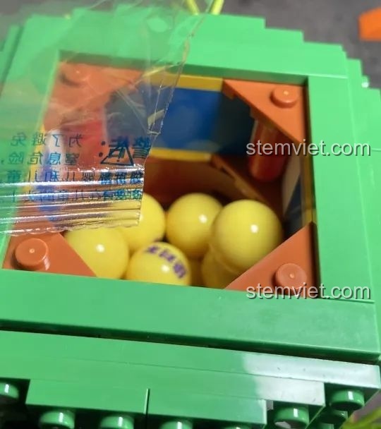 Trứng gashapon màu vàng được đổ vào khoang chứa của đồ chơi mô hình Máy Vặn Trứng Xương Rồng Mexico Pantasy 61007, sẵn sàng để chơi.