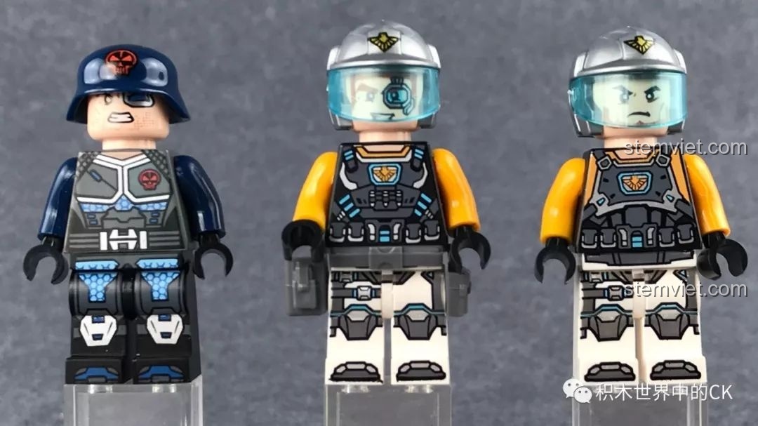 Ba nhân vật minifigure đi kèm bộ đồ chơi lắp ráp QMAN 2703 Xe Chiến Đấu U Linh, với trang phục và mũ bảo hiểm khác nhau.