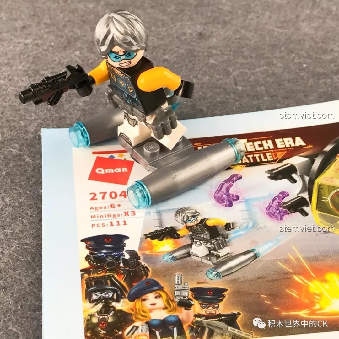 Minifigure đứng trên thiết bị bay từ bộ QMAN 2704 Thiết Bị Trinh Sát Mắt Đen, tạo dáng theo hình ảnh quảng cáo.