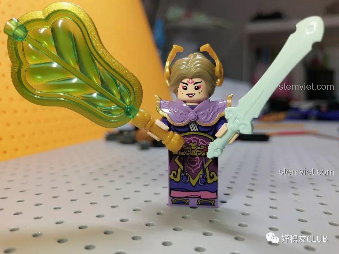 Minifigure Thiết Phiến Công Chúa trong bộ QMAN 3807 Tây Du Ký: Đại Chiến Hồng Hài Nhi, với quạt Ba Tiêu và kiếm, chi tiết khuôn mặt và trang phục được in sắc nét. Đánh giá QMAN 807 Trận chiến Tây Du Ký qua các nhân vật.