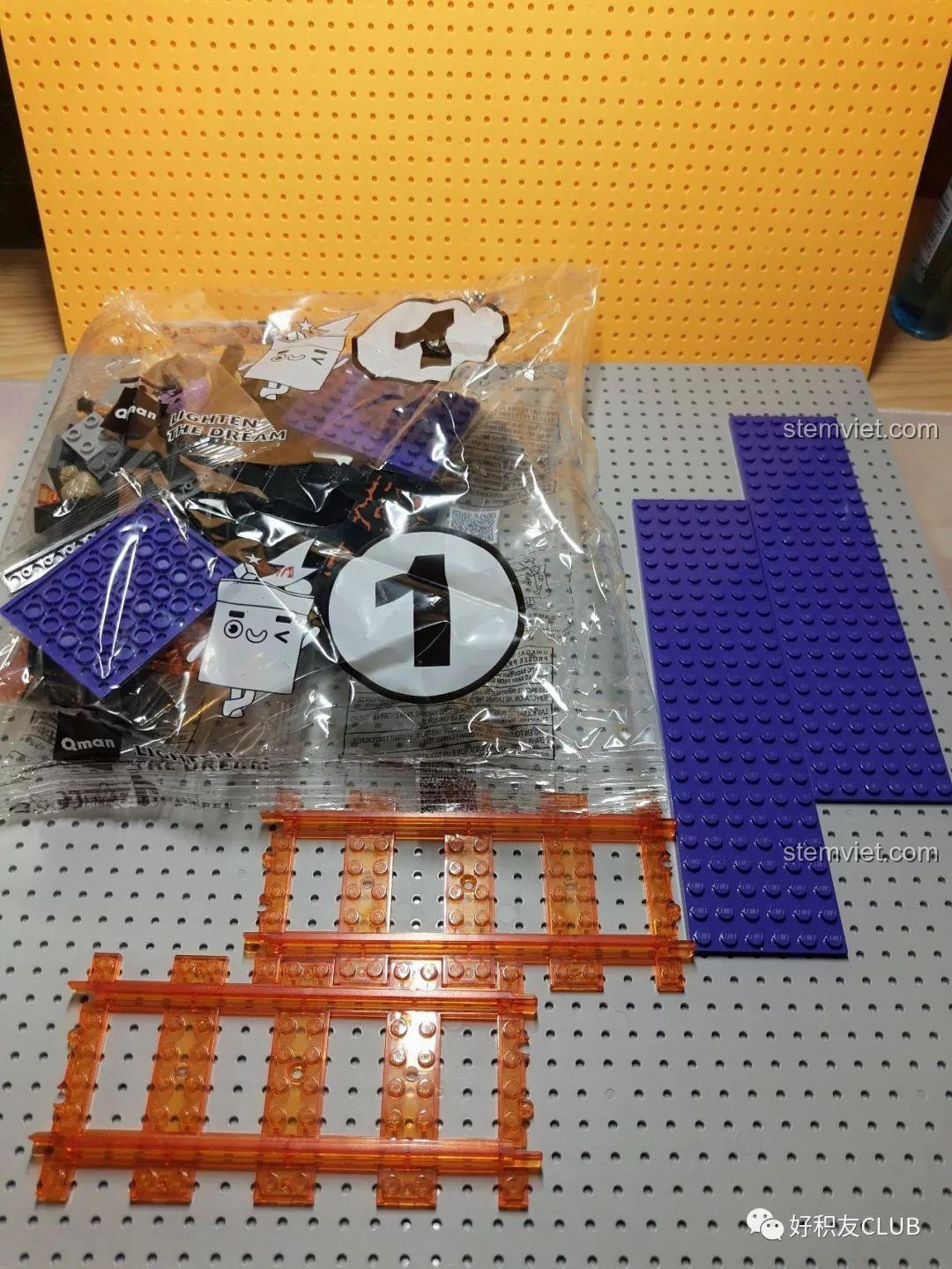 Các mảnh ghép trong túi số 1 của bộ QMAN 3807 Tây Du Ký: Đại Chiến Hồng Hài Nhi, bao gồm các thanh ray trong suốt và tấm đế màu tím, khởi đầu cho công trình. Đánh giá QMAN 807 Trận chiến Tây Du Ký qua từng bước lắp.