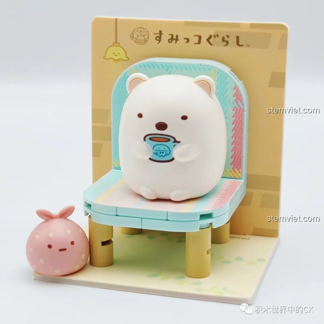 Mô hình Shirokuma và Furoshiki đã lắp hoàn chỉnh, ngồi trên ghế nhỏ, trong bộ đồ chơi xếp hình Sumikko Gurashi 77012.