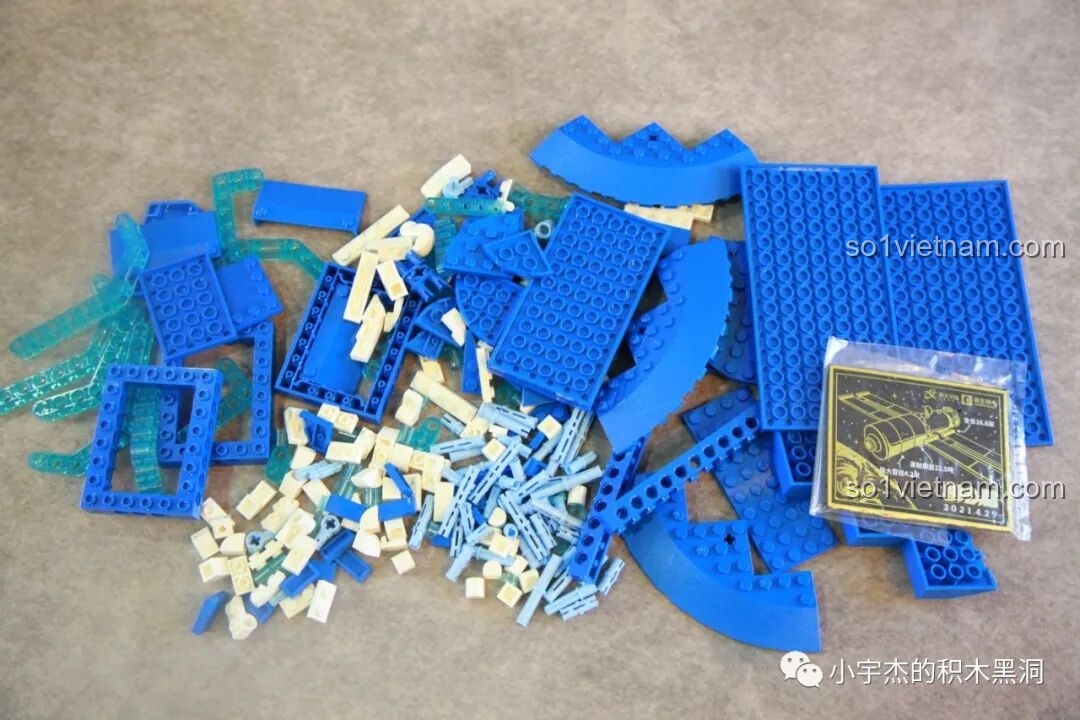 Các mảnh ghép từ túi số 8 của bộ lắp ráp SEMBO 203337 Mô hình Trạm Vũ trụ Thiên Cung được đổ ra, bao gồm nhiều mảnh màu xanh dương và trong suốt.