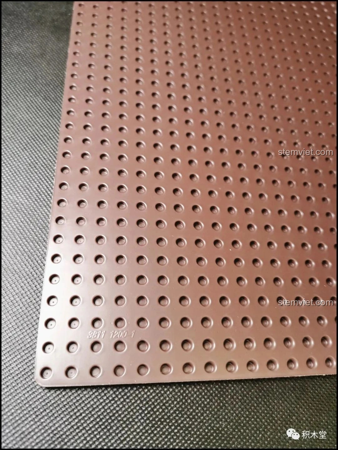 Tấm đế lớn màu nâu sẫm với các lỗ tròn, dùng làm nền cho mô hình Bánh Kem Hộp Quà Sembo 601400