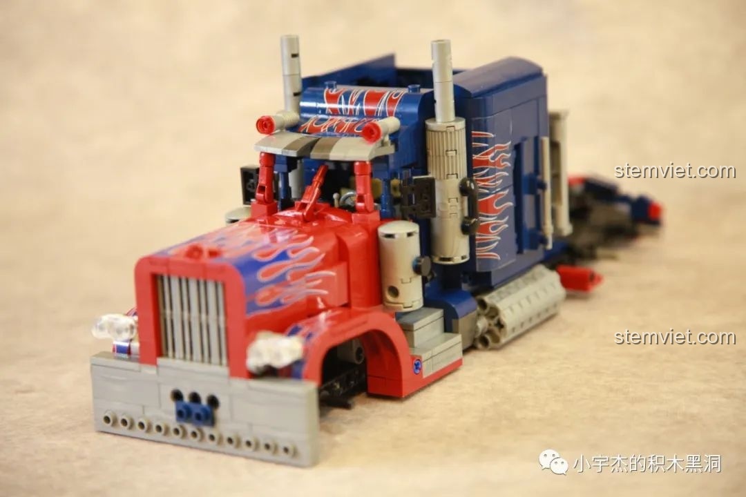 Góc nhìn rộng hơn từ phía trước của mô hình Xe Tải Peterbilt 389 Kéo Lùi Màu Optimus Prime SEMBO, với các chi tiết trang trí.