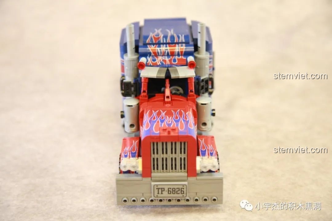 Góc nhìn nghiêng thân xe của mô hình Xe Tải Peterbilt 389 Kéo Lùi Màu Optimus Prime SEMBO, thể hiện họa tiết lửa.