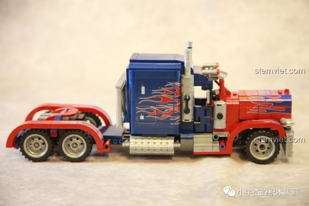 Góc nhìn ngang thân xe của mô hình Xe Tải Peterbilt 389 Kéo Lùi Màu Optimus Prime SEMBO, thể hiện họa tiết lửa.