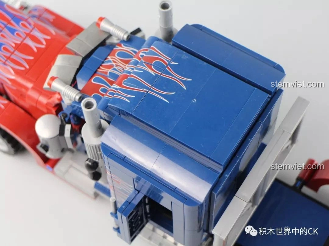 Cận cảnh phần đuôi xe tải Peterbilt 389, với đèn hậu và chắn bùn trang trí họa tiết lửa.